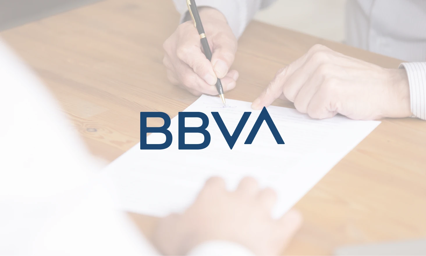 Hombre firmando documentos de reclamación de gastos de hipoteca en el Banco BBVA