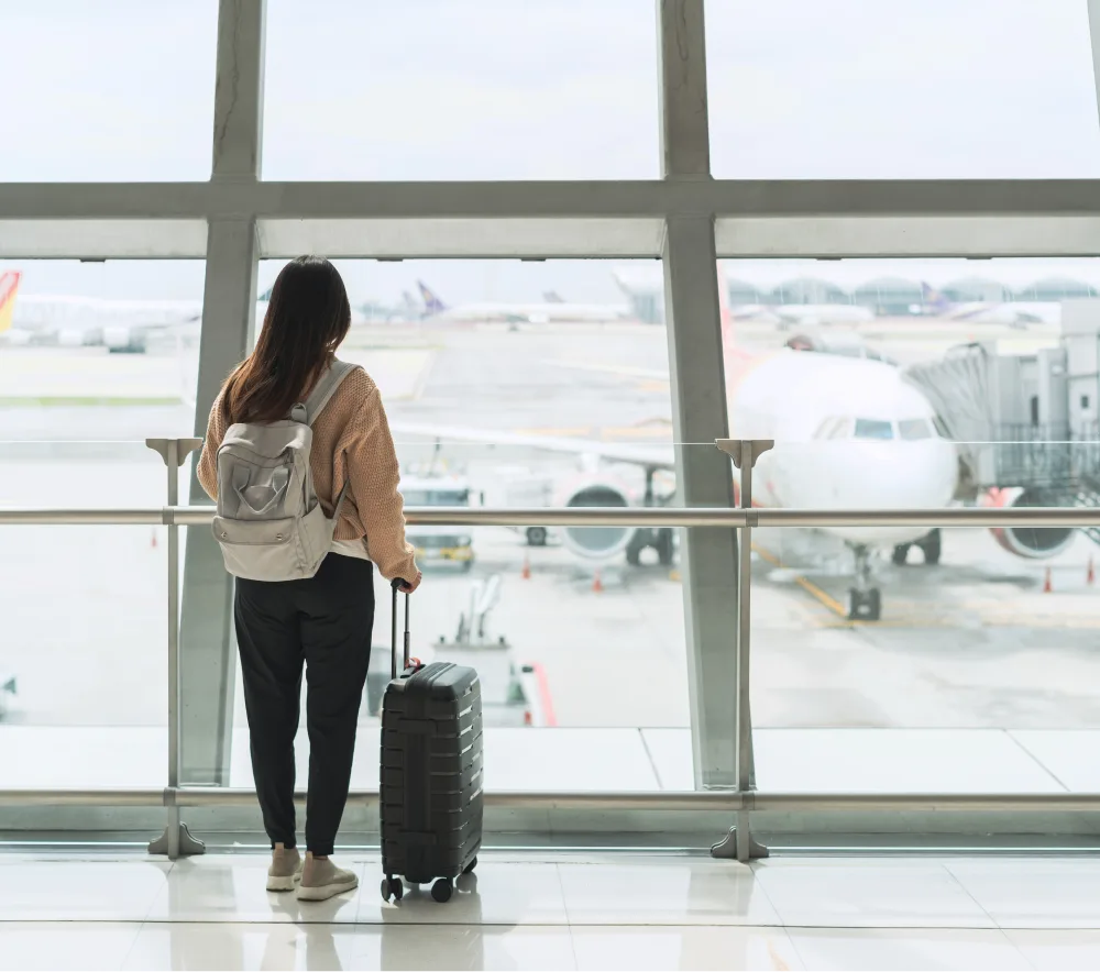 Viajera mirando el avión en el aeropuerto